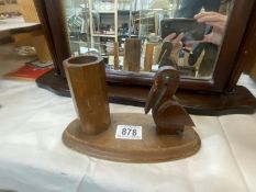 An art deco wooden pen holder of a pelican with green jewelled eye