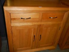 A two door / two drawer oak cupboard. COLLECT ONLY.