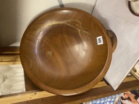 A turned wooden bowl with faint oriental gilt decoration on a wooden stand, 42 cm diameter.