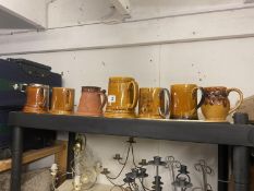 A quantity of glazed tankards and a pottery acorn tankard signed Moy