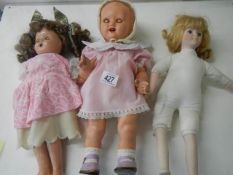 Two vintage dolls and one other.