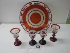 A red glass plate and two pairs of wine glasses.