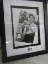A framed and glazed signed photograph of Norman Wisdom.