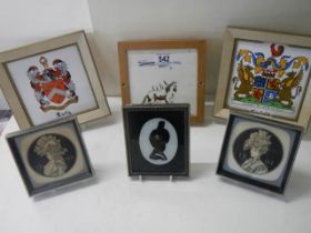 Three framed silhouettes, two coats of arms and one other small picture.