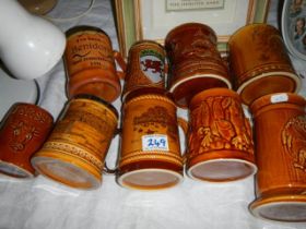 Nine souvenir tankards.