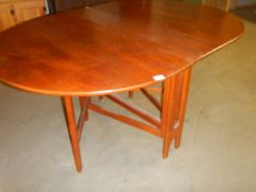An oval teak drop leaf table, COLLECT ONLY.
