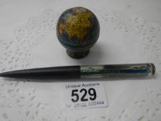 An R M S Titanic novelty pen and a miniature globe on stand.