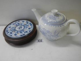 A Victorian Burleigh ware blue and white teapot and a wooden teapot stand with ceramic inset.