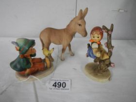 A Beswick donkey and two Goebel figures.