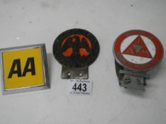 An AA badge and two other car badges.