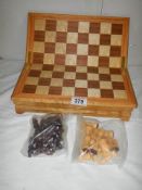 A cased chess set in wooden box with swivel top board.