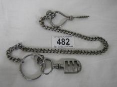 A white metal watch chain with attachments.