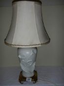 A white ceramic table lamp with brass base