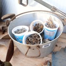 An aluminium jam pan full of nails