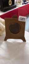 An arts & crafts small brass easel & a photo frame