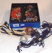 A box of costume jewellery including sea shell necklaces
