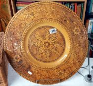 A large carved poker ware charger signed to rear diameter 49.5cm COLLECT ONLY