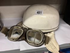 A vintage motor cycle helmet and leather backed goggles (one lens cracked )