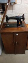 A cabinet cased electric singer sewing machine 78 x 53 x 42cm