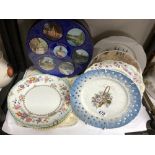 A collection of hanging wall plates & blue tin