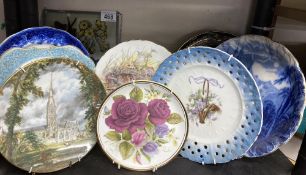 A collection of hanging wall plates and a glass plaque