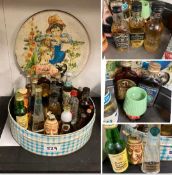 A collection of whiskey and other miniatures in a vintage tin.