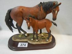 A horse and foal figure on base.