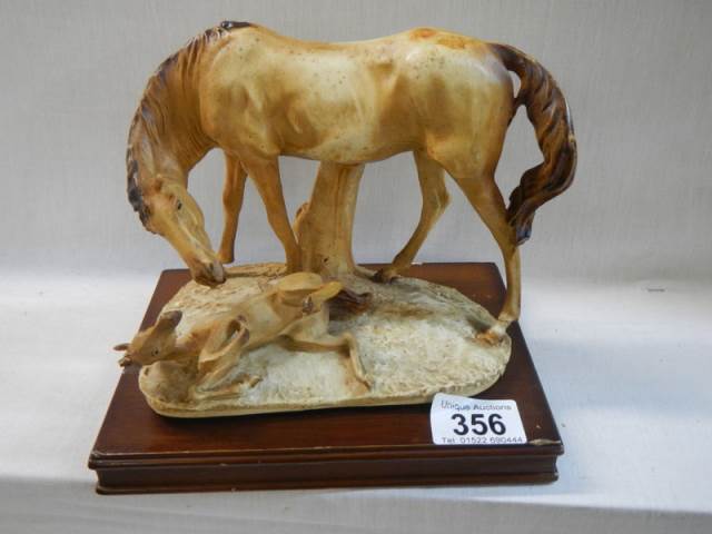 A horse and foal figure on base.