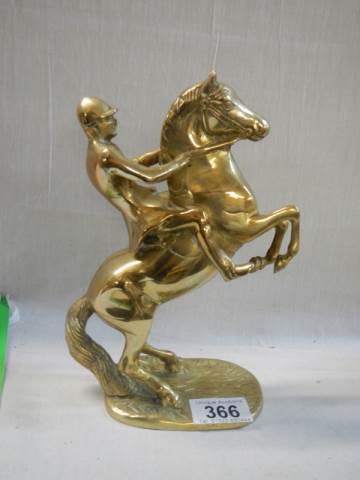 A solid brass rearing horse figure.