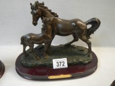 A horse and foal figure on base.