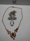 A red and white stone necklace and a cross pendant.