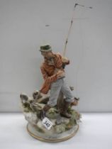 A continental porcelain figure of a fisherman with his dog. COLLECT ONLY.