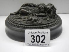 A paperweight featuring a reclining female.