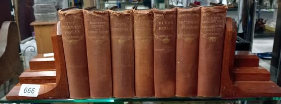 A pair of early 20th century bookends with seven Dickens books.