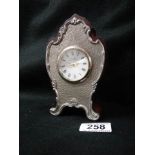 A small late 20th century clock with silver plated front.