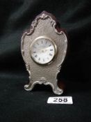 A small late 20th century clock with silver plated front.