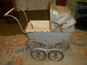 A vintage dolls pram (hood needs attention).