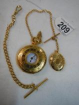 A gold coloured half hunter pocket watch with chain.