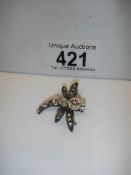 A bee brooch set white stones.