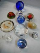 Eleven assorted glass paperweights.