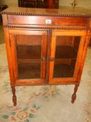 An oak two door glazed cabinet. COLLECT ONLY.