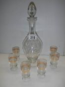 An engraved glass decanter and a set of six gilt rimmed glasses. COLLECT ONLY.