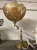 A vintage shell shade on brass counter lever base