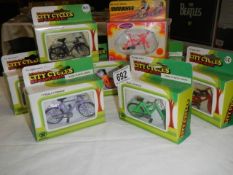 Eight boxed 1/20 scale die cast bicycles.