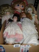 Four porcelain collector's dolls and a rag doll.