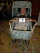 A vintage wicker dolls pram with a vintage doll. COLLECT ONLY.