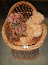 Two Teddy bears on a wicker chair.