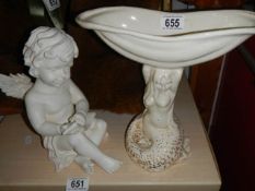 A mermaid soap dish and a cherub figure.