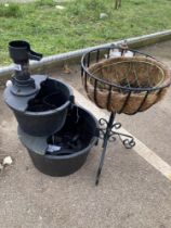 A water feature & metal planter on a stand