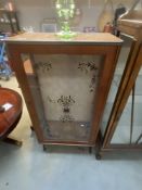 A glass display cabinet with black & gold transfer floral decoration (57cm x 29cm x 110cm)